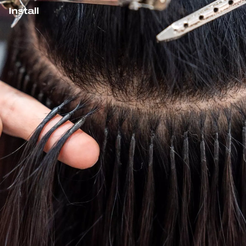 Load image into Gallery viewer, Close-up of keratin tip hair extensions being installed with a hand holding the hair.