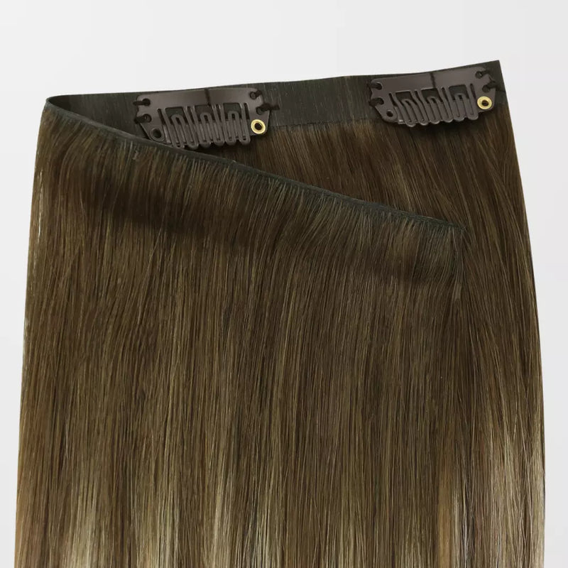 Load image into Gallery viewer, A pack of clip-in hair extensions with straight, medium brown hair featuring subtle warm blonde highlights, attached to black elastic bands with gold metal grommets.