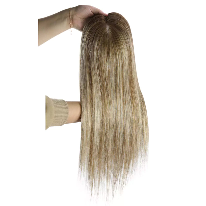 Load image into Gallery viewer, A long hair topper with a warm golden-brown and light blonde ombré color, held up by a hand against a plain white background.
