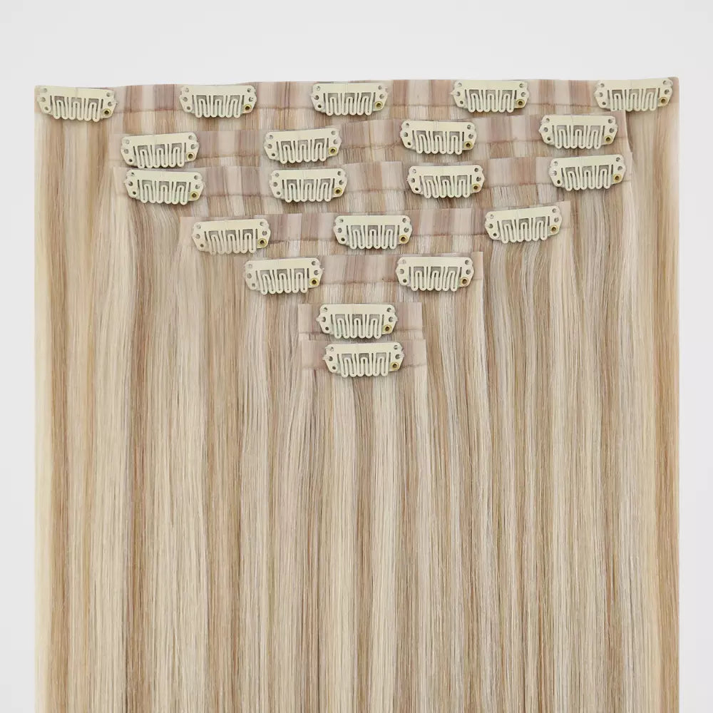 Blonde hair extensions with clips on a white background