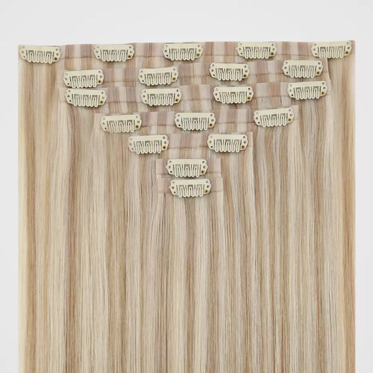 Blonde hair extensions with clips on a white background