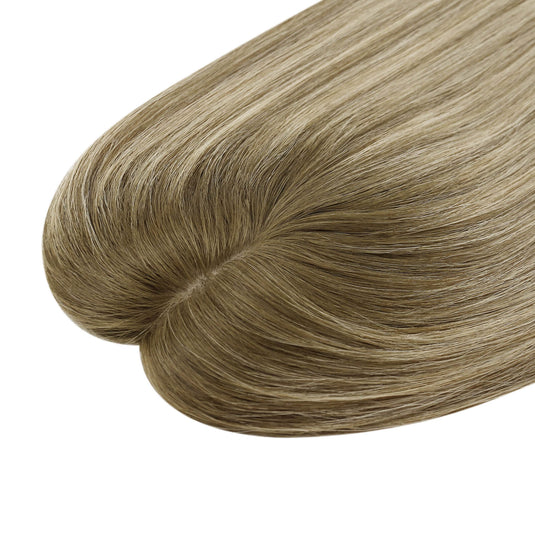 A close-up of a hair topper section with straight, smooth strands in a light ash blonde color, on a plain white background.