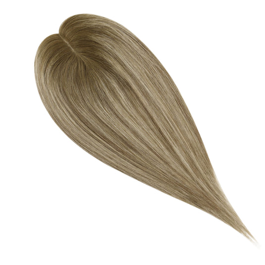 A close-up of a hair topper section with straight, smooth strands in a light ash blonde color, on a plain white background.