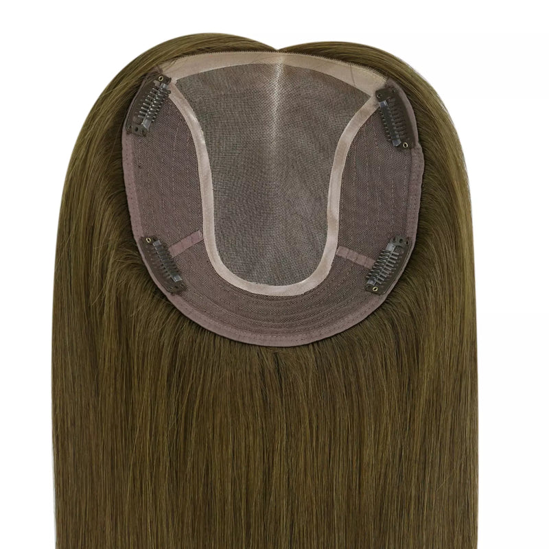Load image into Gallery viewer, Close-up of the underside of a hairpiece extension, showing a semi-sheer mesh crown, brown adhesive base, and multiple metal hair clips holding the piece in place. The attached human hair is light brown to blonde with subtle warm highlights.
