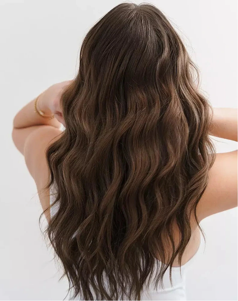 Woman with long, wavy brown hair on a plain background