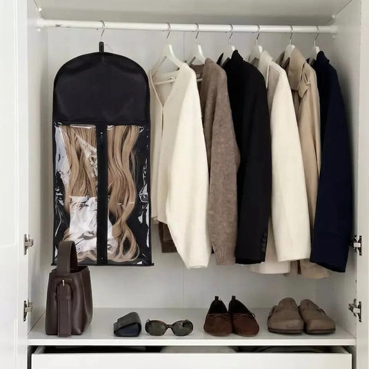 Closet with hanging clothes, a garment bag, shoes, and bags on a shelf.