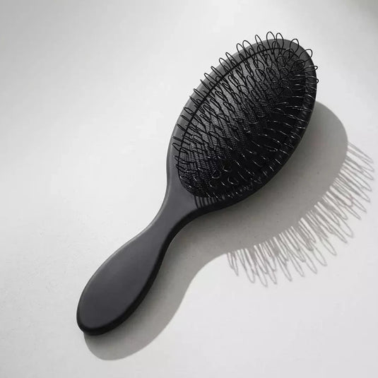 Black hairbrush on a white background
