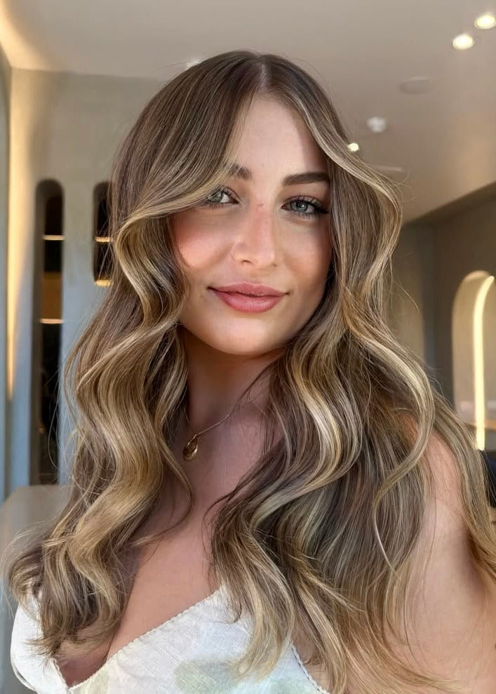 Woman with medium brown with soft highlights hair extensions