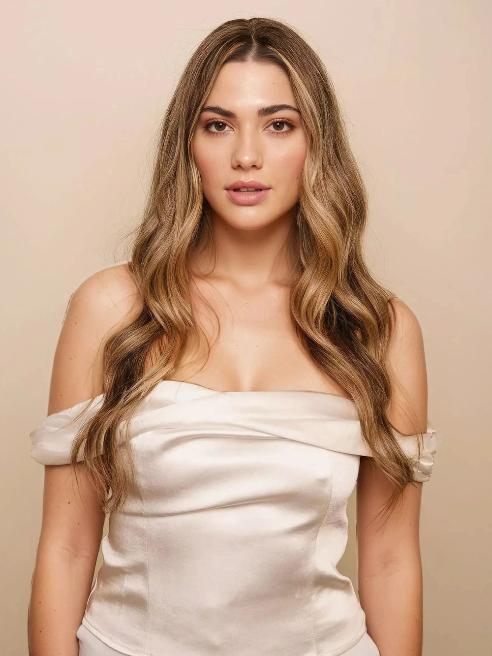 Woman wearing a white off-shoulder top against a beige background