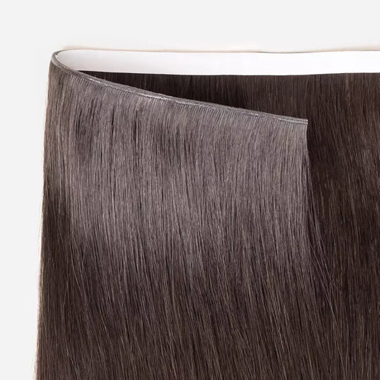 Close-up of brown tape in weft hair extensions on a white background