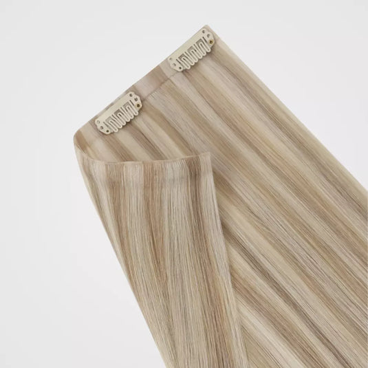 Blonde hair extensions with clips on a white background