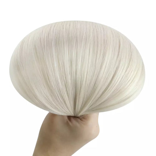 Light blonde wig held by a hand against a white background