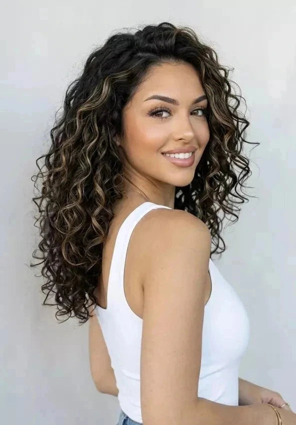 Woman with curly hair wearing a white tank top against a plain background
