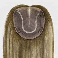 Blonde hairpiece with a brown base on a white background