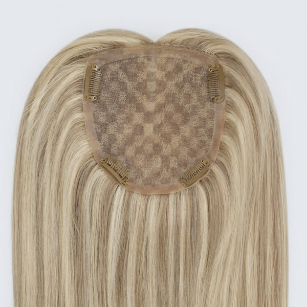 Blonde hair extension with a clip on a white background