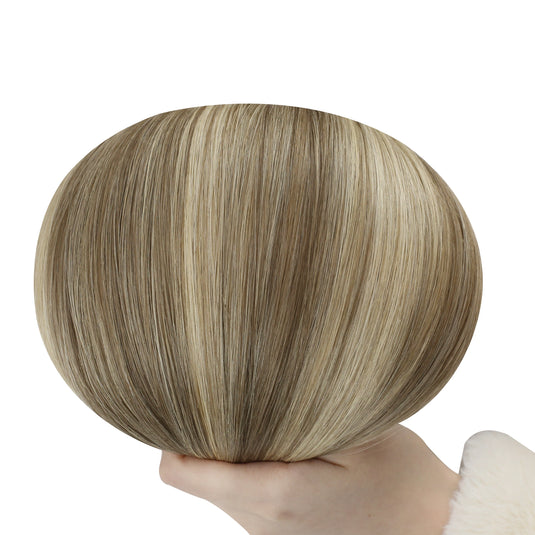 Hand holding a butterfly weft with brown and blonde color on a white background