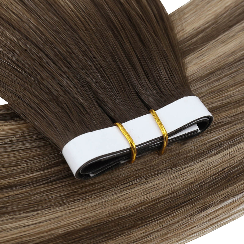 Load image into Gallery viewer, One bundle of straight invisible tape-in weft hair extensions featuring balayage brown, secured with white bands and gold elastic ties, displayed on a white background.
