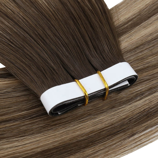 One bundle of straight invisible tape-in weft hair extensions featuring balayage brown, secured with white bands and gold elastic ties, displayed on a white background.