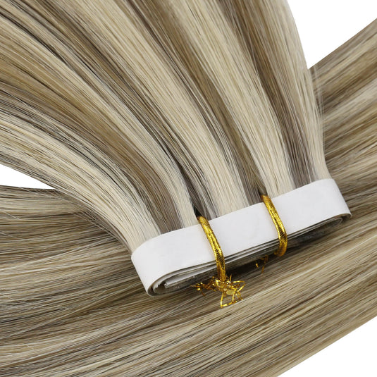 Close-up view of blonde highlight tape-in weft hair extensions.