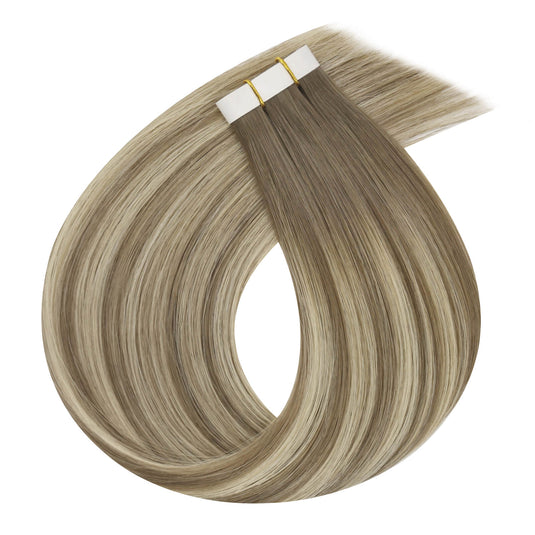 One bundle of straight invisible tape-in weft hair extensions featuring blonde highlights, secured with white bands and gold elastic ties, displayed on a white background.