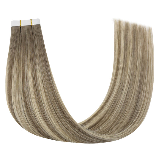 One bundle of straight invisible tape-in weft hair extensions featuring blonde highlights, secured with white bands and gold elastic ties, displayed on a white background.