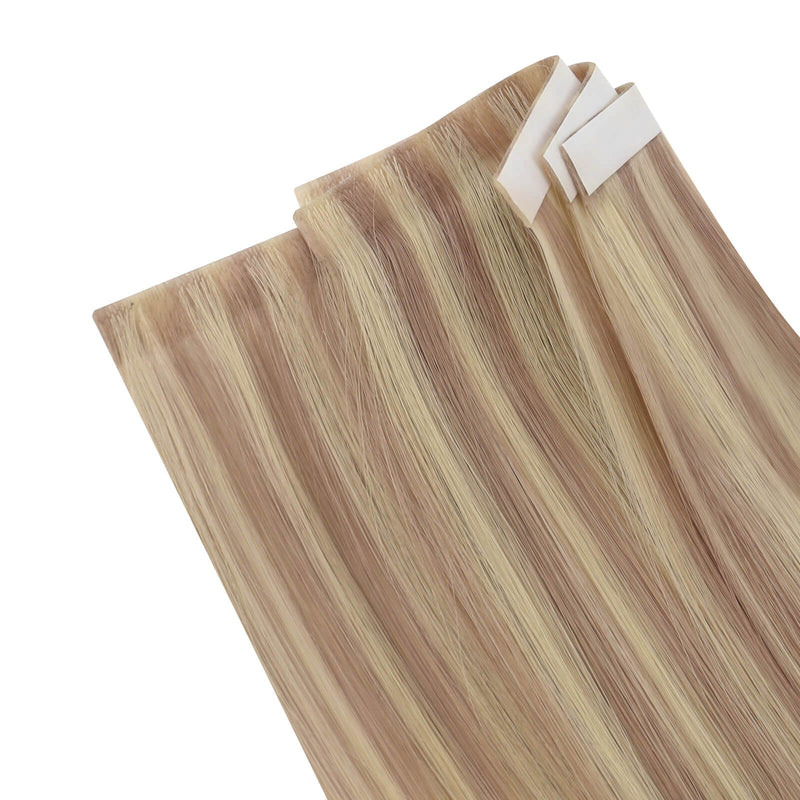 Load image into Gallery viewer, Three bundles of straight invisible tape-in weft hair extensions with pink blonde highlights on a white background.
