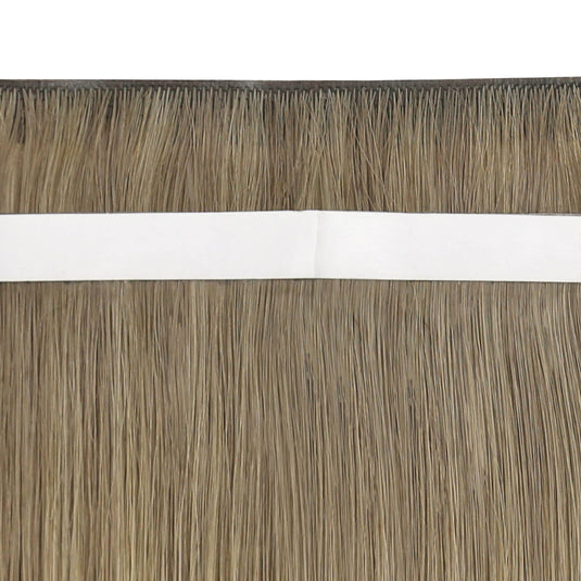 Close-up view of blonde highlight tape-in weft hair extensions.