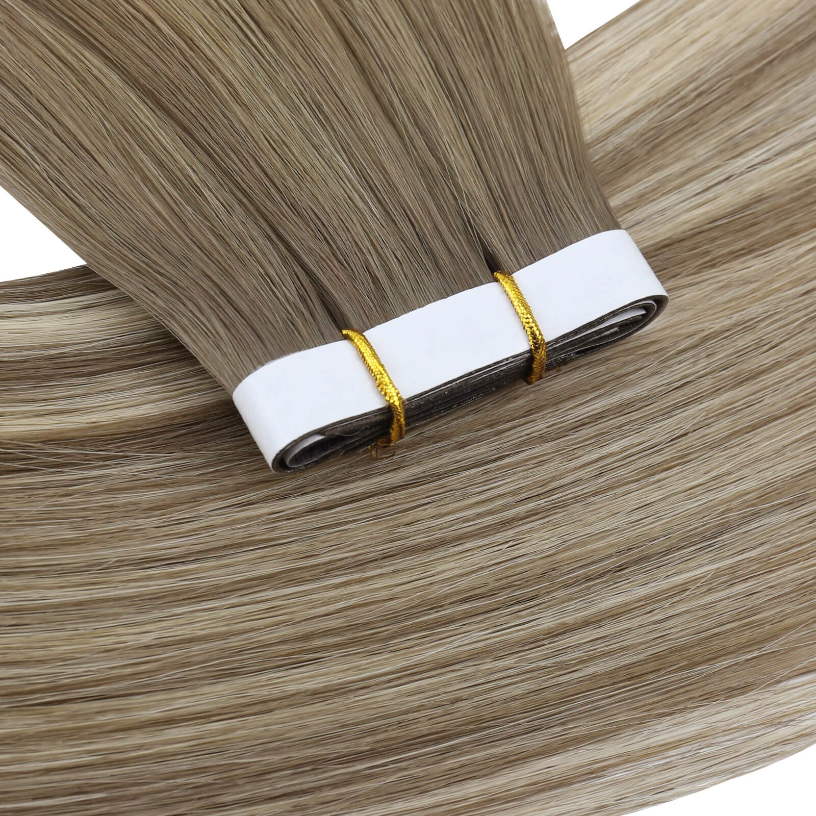One bundle of straight invisible tape-in weft hair extensions featuring blonde highlights, secured with white bands and gold elastic ties, displayed on a white background.