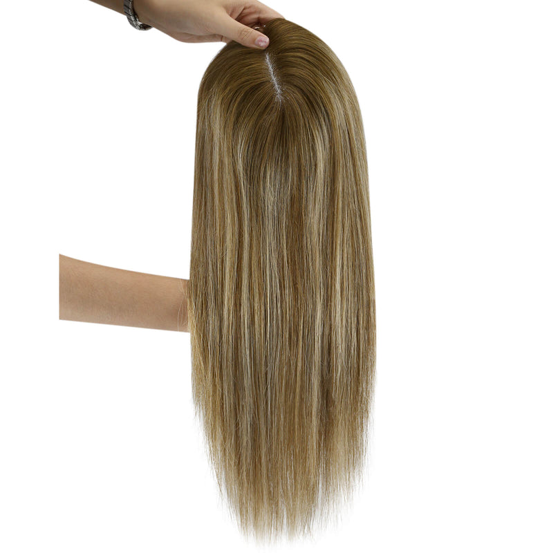 Load image into Gallery viewer, A long hairtopper with a warm golden-brown and light blonde ombré color, held up by a hand against a plain white background.
