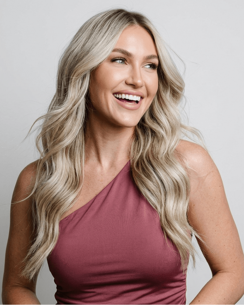 Woman with long, blonde hair against a gray background