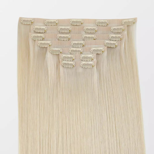 Blonde hair extensions with clips on a white background