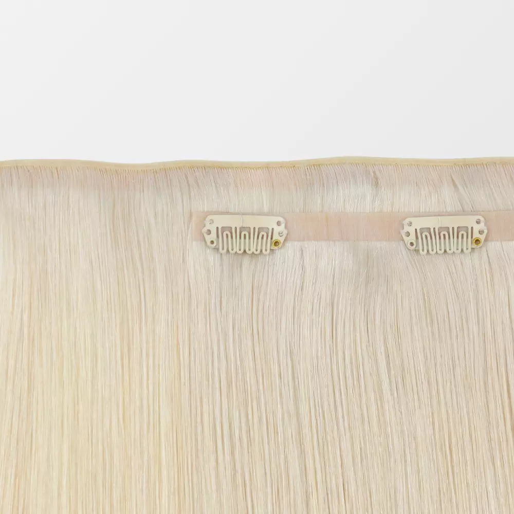 Blonde hair extensions with clips on a white background