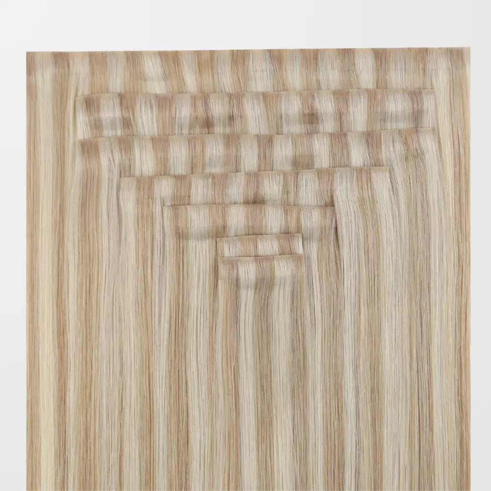 Set of blonde clip in hair extensions on a white background
