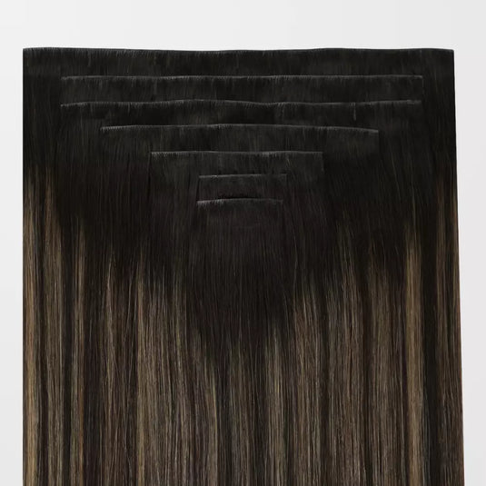 Set of balayage brown clip in hair extensions on a white background