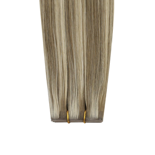 Invisible butterfly weft hair extensions with brown and blonde highlights on a white background