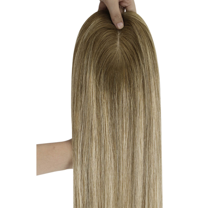 Load image into Gallery viewer, A long topper with a highlighted blonde-brown color, held up by a hand to show the hair texture and parting against a white background.
