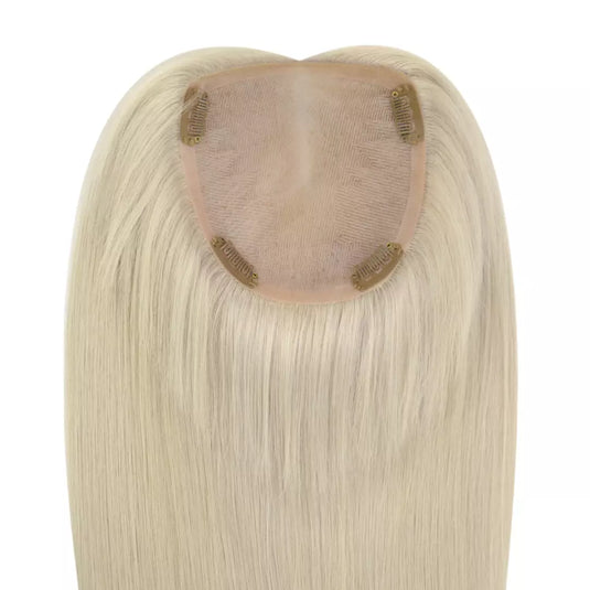 A close-up of a hairpiece extension with straight, shoulder-length blonde hair and a blonde checkered adhesive inner cap on a white background.