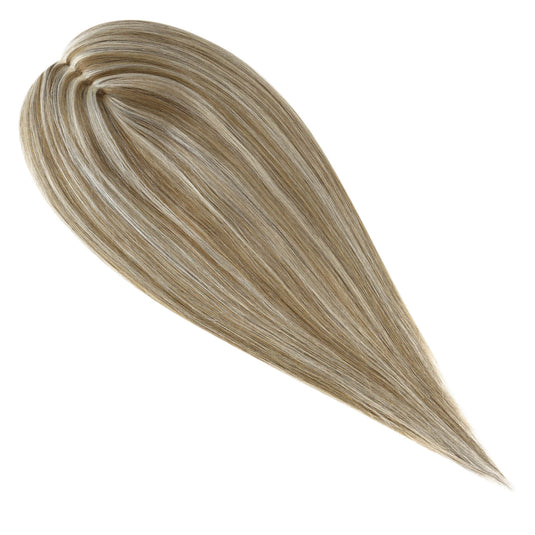 A close-up of a topper section with straight, glossy strands in a blended light brown and blonde balayage pattern, isolated on a white background.