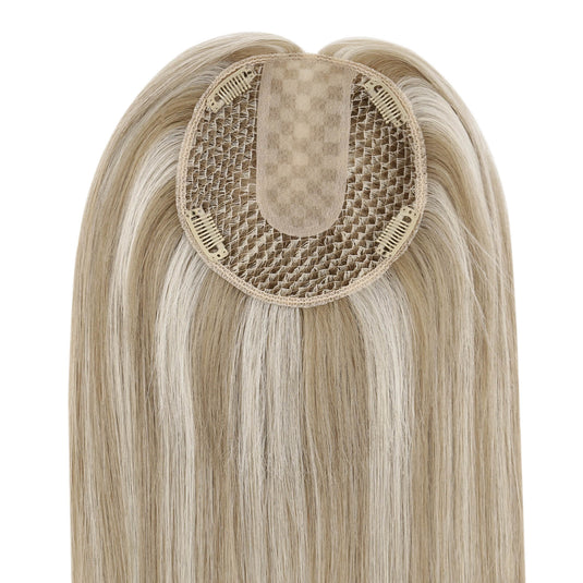 A close-up of a hairpiece with long straight light blonde hair and a beige mesh attachment center, shown against a plain white background.