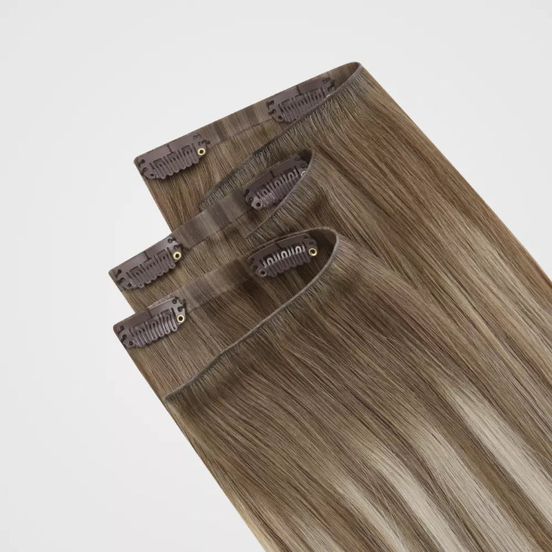 Load image into Gallery viewer, Set of clip hair extensions on a light gray background
