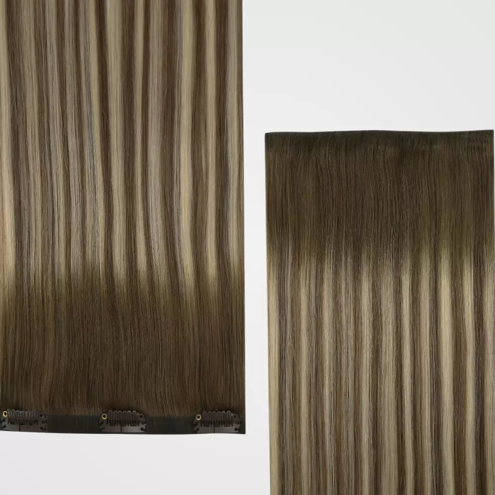 A close-up of blonde highlights clip in hair extensions on a white background