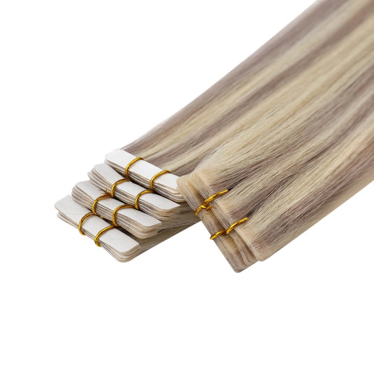 A bundle of invisible tape in hair extensions with a light ash blonde and brown ombré color