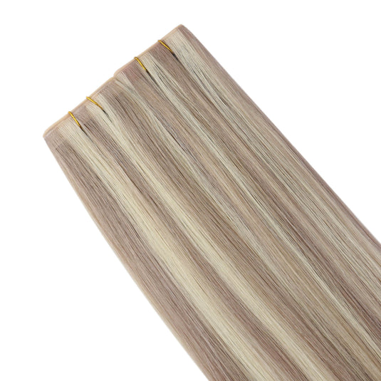 Four butterfly weft hair extension bundles with light ash blonde and beige highlights, shown against a solid white background.