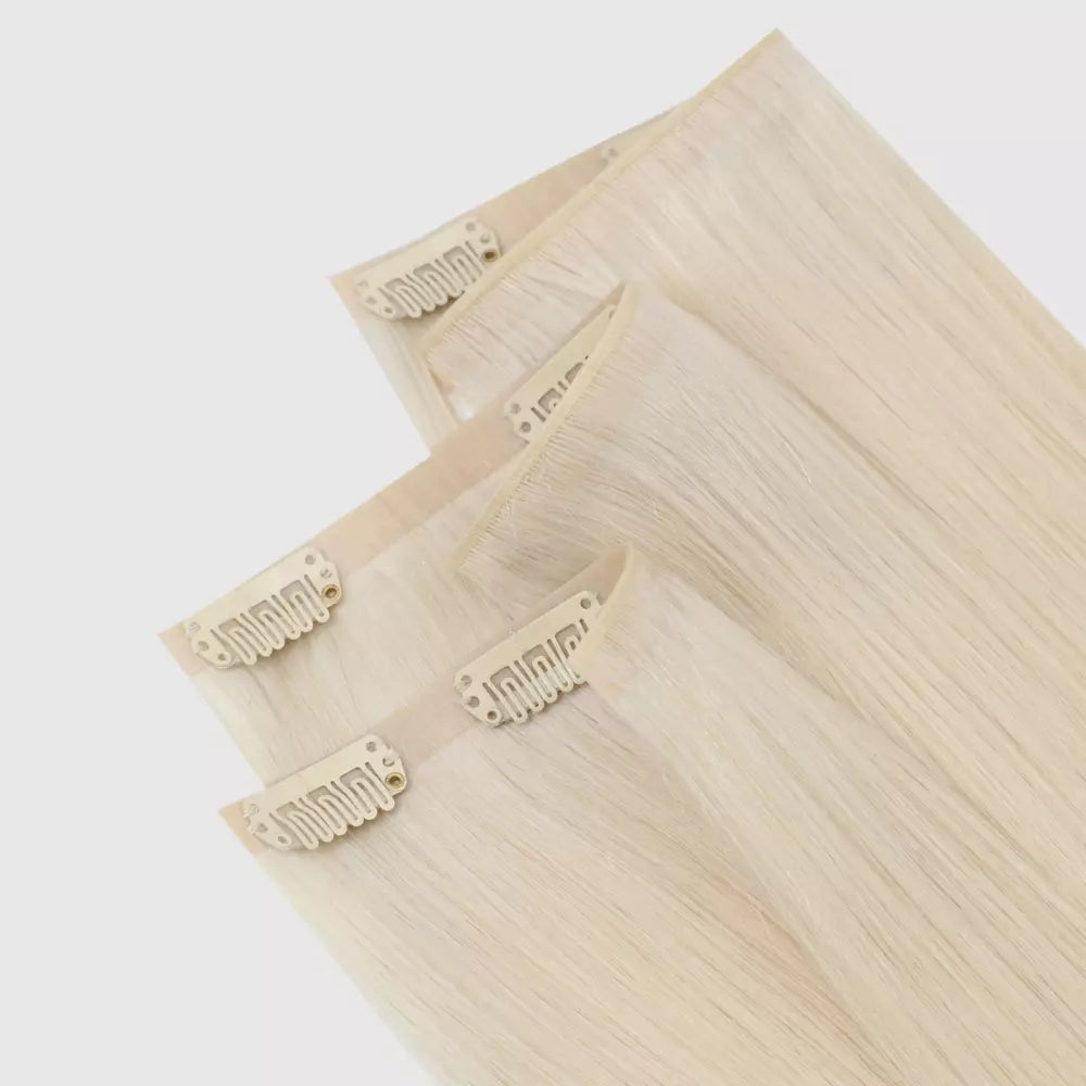 Set of blonde hair extensions with clips on a white background
