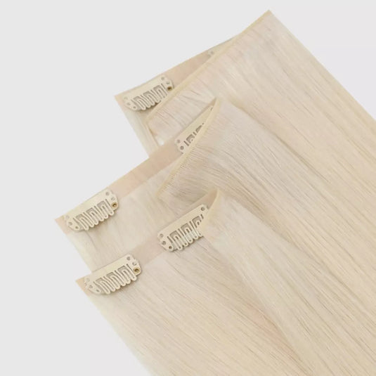 Set of blonde hair extensions with clips on a white background