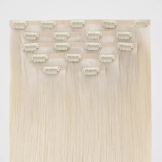 Set of blonde invisible hair extensions with clips on a white background