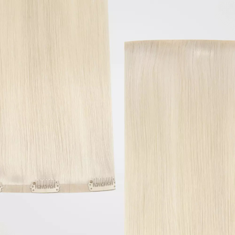 Two strands of blonde clip in hair extensions on a light background