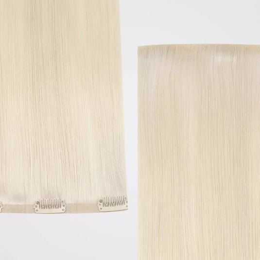 Two strands of blonde clip in hair extensions on a light background