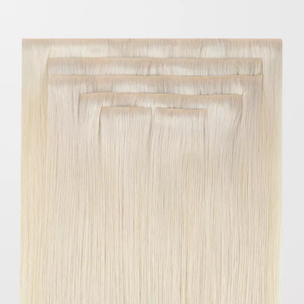 Set of blonde invisible clip in hair extensions on a white background