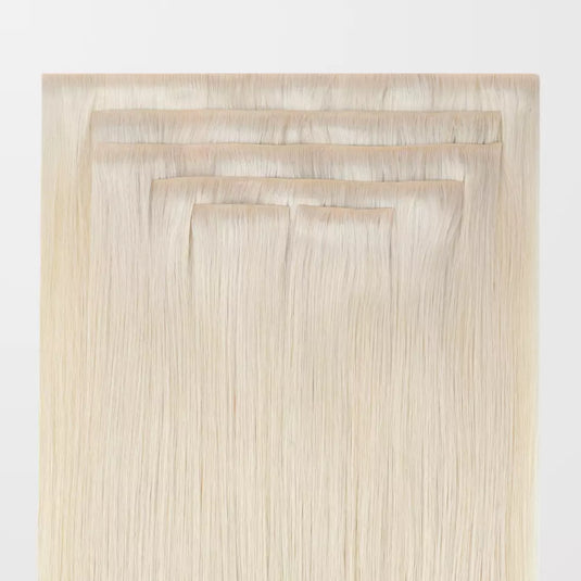 Set of blonde invisible clip in hair extensions on a white background